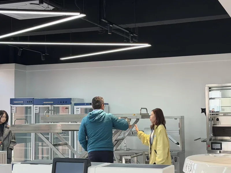 Customer examining body lift and mortuary trolley in Roundfin showroom