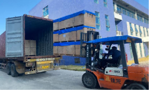 A Jialong machine being loaded by forklift into a shipping container.